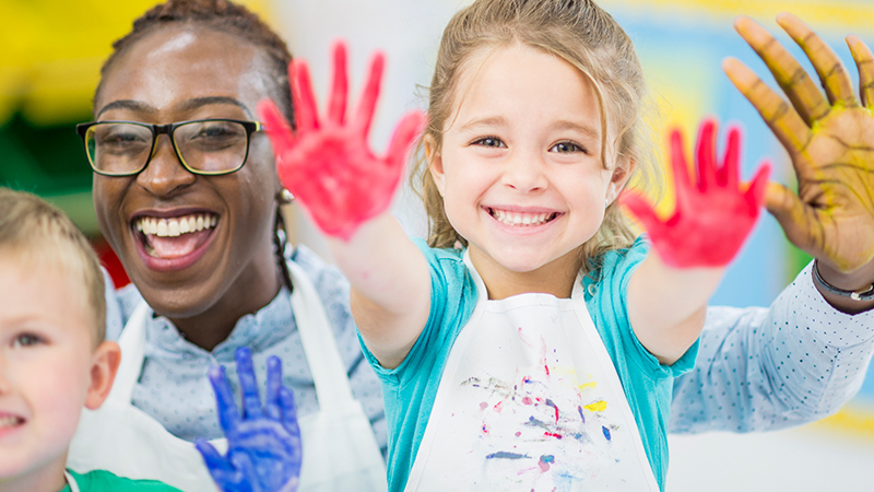 Teacher Rentention article featuring photo with student who has paint-stained hands.